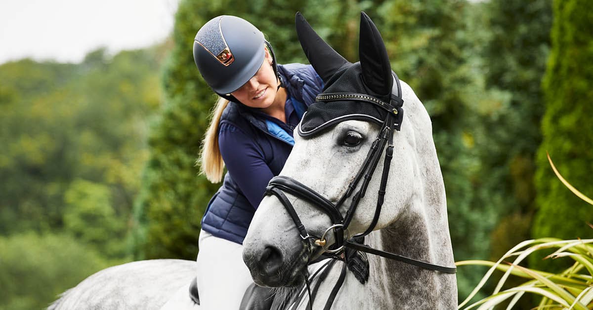 woman touching a horse while riding it