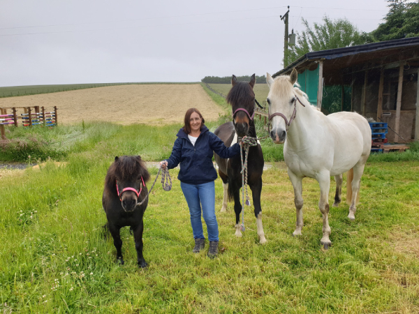 woman with two horses and a pony