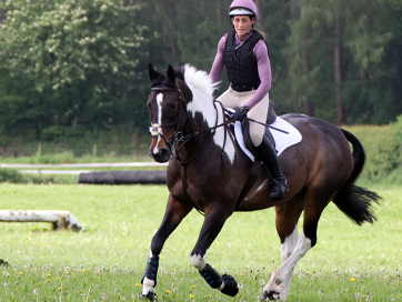 woman on a horse doing the heart sign 