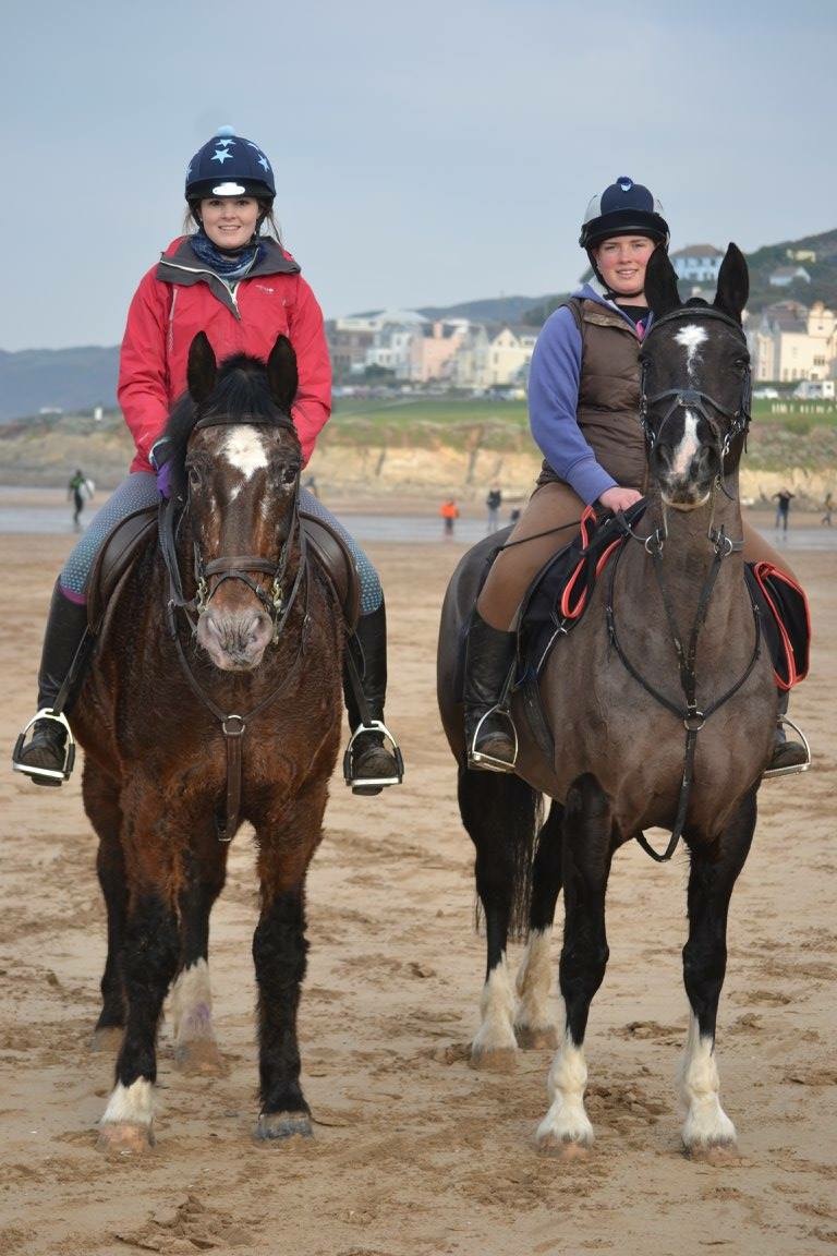 two girls riding their horses